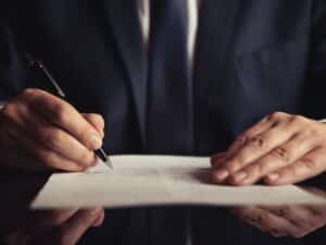A New York personal injury attorney writing a note on a legal document.