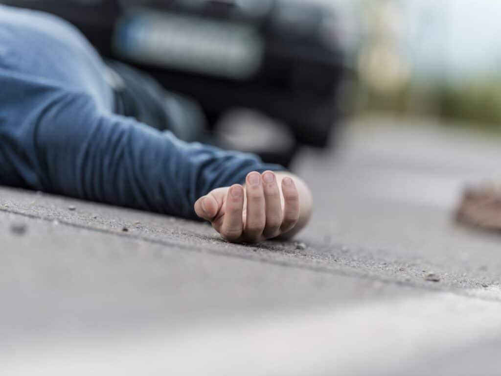 An unconscious man in the street after a hit-and-run accident.