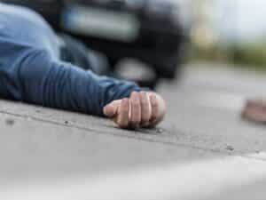 An unconscious man in the street after a hit-and-run accident.