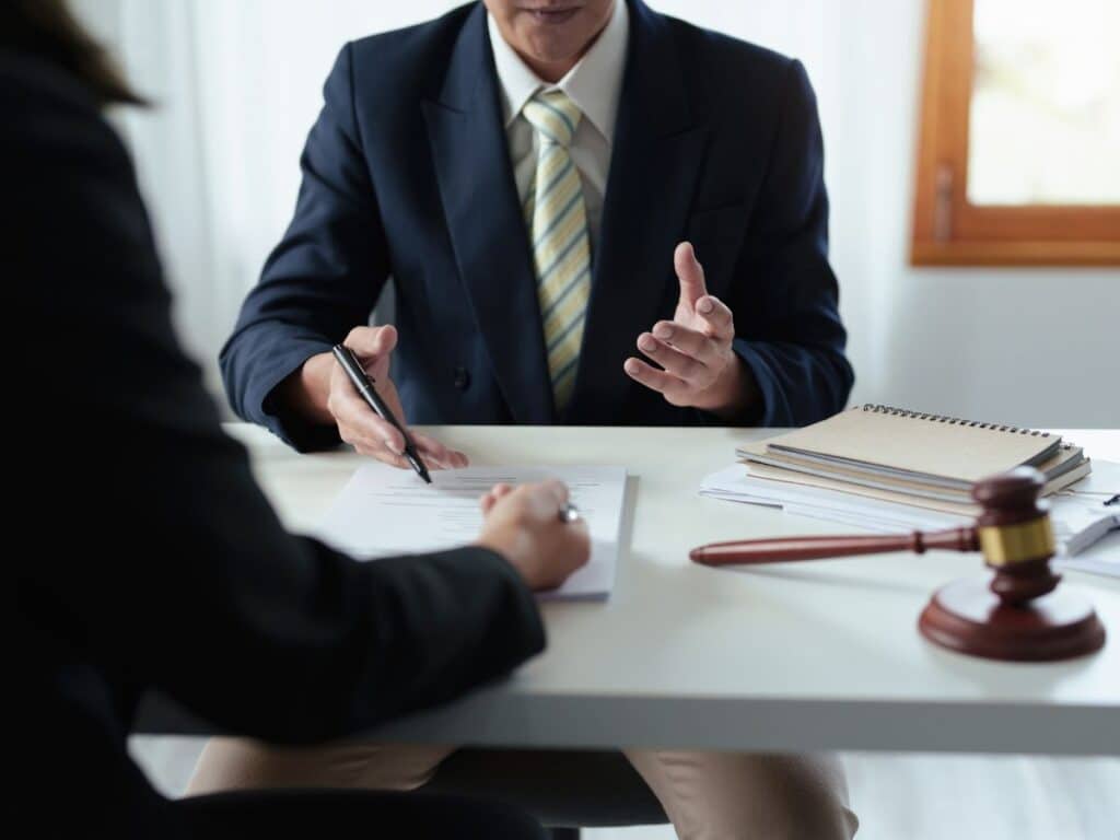 A personal injury lawyer explaining the legal process to a client sitting across from him.