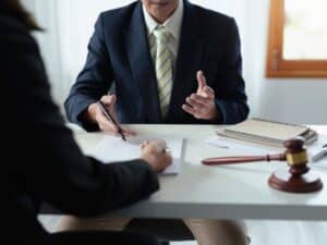 A personal injury lawyer explaining the legal process to a client sitting across from him.