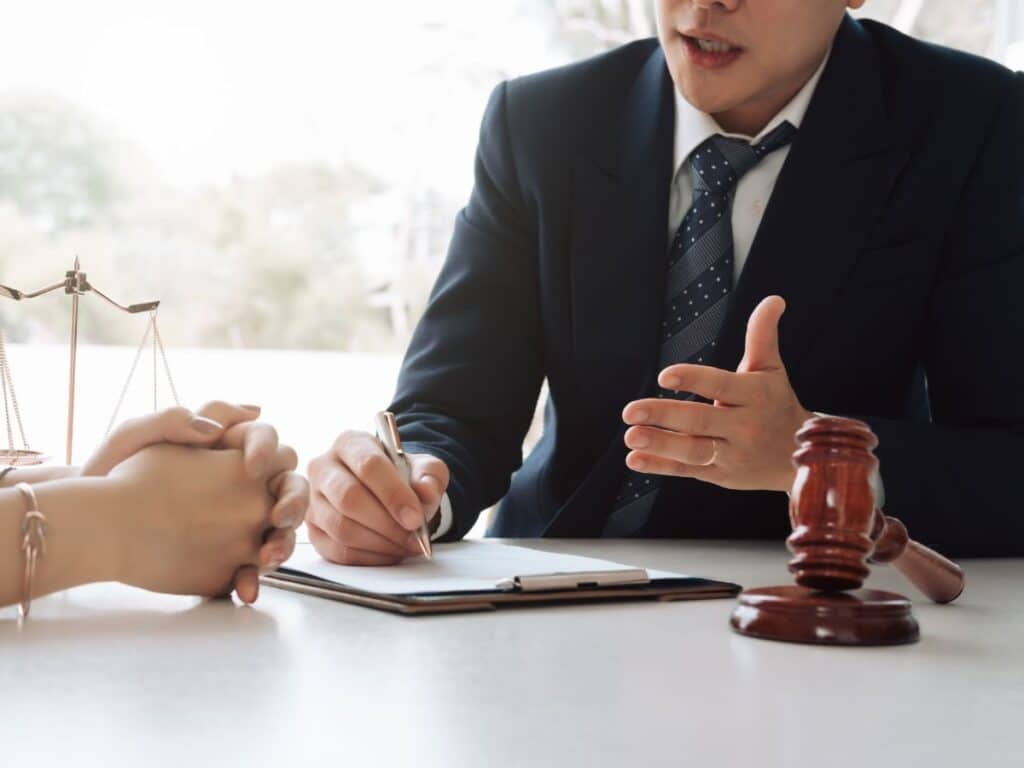 A personal injury attorney sitting at his desk while speaking with a client.