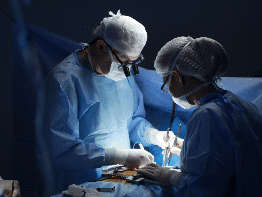 Two surgeons performing a surgical procedure on a patient.