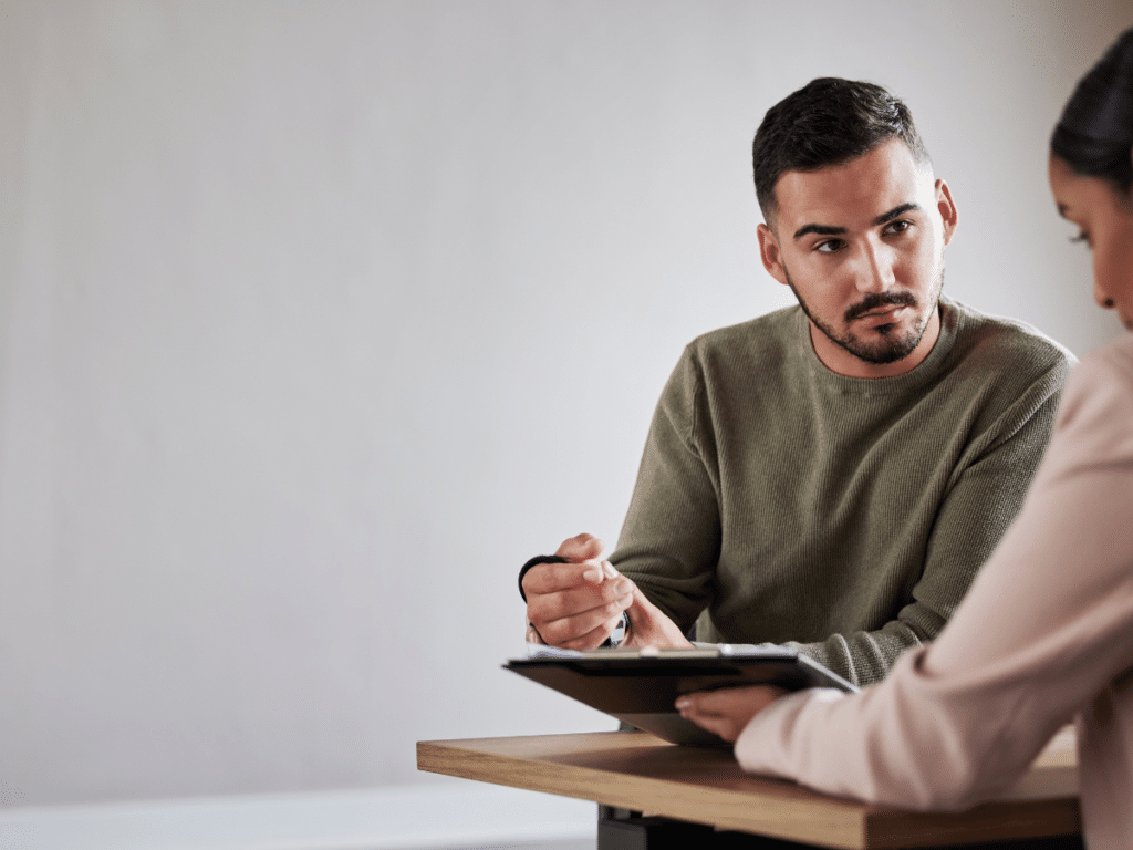 A man with an arm brace assessing his options with his New York personal injury attorney.
