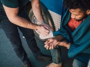 A man receiving medical care from a paramedic after a car accident.