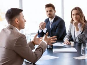 A group of personal injury attorneys listening to a plaintiff during a legal deposition.
